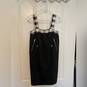 Cropped black mini dress with square neck, pockets and zip details